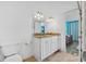 Bright bathroom featuring a double vanity with granite countertop and white cabinets at 2424 W Tampa Bay Blvd # G204, Tampa, FL 33607