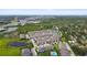 A wide aerial shot showcases a community with serene ponds, lush trees, and manicured lawns around modern townhouses at 2432 Golden Pasture Cir, Clearwater, FL 33764