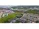 A high angle view of a community featuring ponds, roads, and modern-style townhomes surrounded by grass and trees at 2432 Golden Pasture Cir, Clearwater, FL 33764