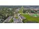 A wide aerial view of a townhome community with green spaces and roads, showing nearby buildings in the distance at 2432 Golden Pasture Cir, Clearwater, FL 33764