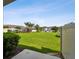 A lovely green backyard features a view of neighboring buildings and the community pool in the distance at 2432 Golden Pasture Cir, Clearwater, FL 33764