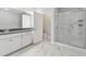 A modern bathroom with white cabinetry, marble floors, and a glass shower at 2432 Golden Pasture Cir, Clearwater, FL 33764