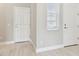 Neutral entryway featuring neutral walls, wood look tile flooring, a window and two white doors at 2432 Golden Pasture Cir, Clearwater, FL 33764