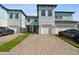 Charming two-story townhomes with light blue accents and brick paved driveways at 2432 Golden Pasture Cir, Clearwater, FL 33764
