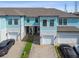 Stylish townhome exterior with blue siding, brick driveway, and attached garage at 2432 Golden Pasture Cir, Clearwater, FL 33764