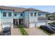 A stunning townhome exterior with blue siding, brick driveway, and attached garage at 2432 Golden Pasture Cir, Clearwater, FL 33764