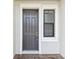 Close-up of a stylish front door with a window, framed by white trim at 2432 Golden Pasture Cir, Clearwater, FL 33764