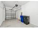 Spacious garage features an automatic garage door, epoxy flooring and multiple city trash bins at 2432 Golden Pasture Cir, Clearwater, FL 33764