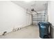 Bright garage features an automatic garage door, white walls, epoxy flooring and city trash bin at 2432 Golden Pasture Cir, Clearwater, FL 33764