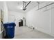 Well lit garage featuring automatic garage door, epoxy flooring, water heater and multiple city trash bins at 2432 Golden Pasture Cir, Clearwater, FL 33764