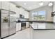 Bright kitchen features stainless steel appliances, white cabinets, gray countertops and view of window at 2432 Golden Pasture Cir, Clearwater, FL 33764