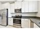 Bright kitchen features stainless steel appliances, white cabinets, and gray countertops at 2432 Golden Pasture Cir, Clearwater, FL 33764