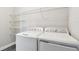 Bright laundry room featuring a washer, dryer, and wire shelving for storage at 2432 Golden Pasture Cir, Clearwater, FL 33764