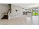 Spacious living area showcasing wood-look tile, a staircase, and a modern kitchen at 2432 Golden Pasture Cir, Clearwater, FL 33764