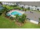 Aerial view of a community pool with lounge chairs and a covered pavilion surrounded by greenery at 2432 Golden Pasture Cir, Clearwater, FL 33764