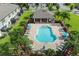 Aerial view of a community pool with lounge chairs and a covered pavilion, surrounded by lush landscaping at 2432 Golden Pasture Cir, Clearwater, FL 33764