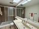 Well-lit bathroom featuring a shower with glass doors and ample counter space at 2541 Laurelwood Dr # 8C, Clearwater, FL 33763