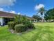Well-maintained home exterior boasts lush landscaping with a palm tree and green lawn under a bright blue sky at 2541 Laurelwood Dr # 8C, Clearwater, FL 33763