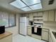 Efficient kitchen featuring essential appliances, white cabinets, and skylight at 2541 Laurelwood Dr # 8C, Clearwater, FL 33763
