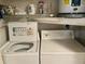 Functional laundry area equipped with a white washing machine and dryer, providing convenience for laundry tasks at 2541 Laurelwood Dr # 8C, Clearwater, FL 33763
