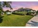 View of the well manicured lawn, landscaping, screen enclosed lanai of this beautiful home at 26 Concord Dr, Dunedin, FL 34698
