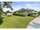 Spacious backyard featuring a well-maintained lawn and a screened-in pool for outdoor enjoyment at 26 Concord Dr, Dunedin, FL 34698