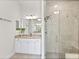 Bright bathroom featuring granite countertop, white cabinets, and glass-enclosed shower at 26 Concord Dr, Dunedin, FL 34698