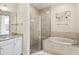 Bright bathroom featuring a tiled shower, a soaking tub, and a granite vanity at 26 Concord Dr, Dunedin, FL 34698