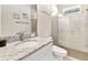 Modern bathroom featuring a granite countertop vanity and a sleek, glass-enclosed shower with decorative tiling at 26 Concord Dr, Dunedin, FL 34698