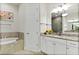 Bathroom featuring a soaking tub, a granite vanity, and tile floors at 26 Concord Dr, Dunedin, FL 34698