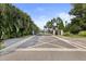 Gated community entrance with brick pavers and lush landscaping, providing privacy and security at 26 Concord Dr, Dunedin, FL 34698