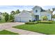 Charming single-Gathering home featuring a well-manicured lawn, 3 car garage, and lush landscaping at 26 Concord Dr, Dunedin, FL 34698