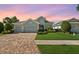 Beautiful home featuring a three car garage, paver driveway and mature landscaping at 26 Concord Dr, Dunedin, FL 34698