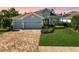 Beautiful home featuring a three car garage, paver driveway and mature landscaping at 26 Concord Dr, Dunedin, FL 34698