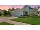 Beautiful home featuring a three car garage, paver driveway and mature landscaping at 26 Concord Dr, Dunedin, FL 34698