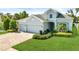 Charming single-Gathering home featuring a well-manicured lawn, 3 car garage, and lush landscaping at 26 Concord Dr, Dunedin, FL 34698