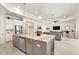 This open kitchen features a large island with stone counters, pendant lights, and views into the living room at 26 Concord Dr, Dunedin, FL 34698