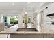 Close-up of the kitchen island with seating, featuring stone countertops and views to the outdoor living space at 26 Concord Dr, Dunedin, FL 34698