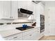 Bright kitchen showcasing white cabinets, stainless steel appliances, and quartz countertops at 26 Concord Dr, Dunedin, FL 34698