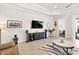Open living room with sleek media center, tile floors, modern decor, and access to the outdoor living space at 26 Concord Dr, Dunedin, FL 34698