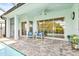 Inviting covered patio adjacent to the pool features comfortable seating and views of the backyard at 26 Concord Dr, Dunedin, FL 34698