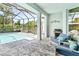 Inviting screened-in pool area with comfortable seating, outdoor grill and lush greenery at 26 Concord Dr, Dunedin, FL 34698