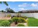 The backyard boasts lush landscaping, raised garden beds, and a white vinyl fence at 2728 Abbey Grove Dr, Valrico, FL 33594
