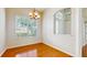 Sunlit dining room featuring wood floors, a modern chandelier, and a large window with bright light at 2728 Abbey Grove Dr, Valrico, FL 33594