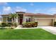 Charming single-story home with a red front door, lush landscaping, and a well-maintained lawn at 2728 Abbey Grove Dr, Valrico, FL 33594