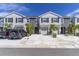 Charming two-story townhome featuring a two-car driveway, one car garage, and tropical landscaping at 2801 Midnight Pearl Dr, Sarasota, FL 34240