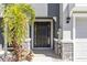 Beautiful paneled front door with sidelights framed by stone accents and lush landscaping at 2801 Midnight Pearl Dr, Sarasota, FL 34240