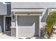 Close up of the one car garage door and front door with decorative stone accents at 2801 Midnight Pearl Dr, Sarasota, FL 34240