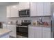 Contemporary kitchen features granite counters, stainless appliances, and sleek white cabinets at 2801 Midnight Pearl Dr, Sarasota, FL 34240