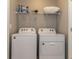 Well-lit laundry area featuring a modern washer and dryer set with overhead shelving at 2801 Midnight Pearl Dr, Sarasota, FL 34240